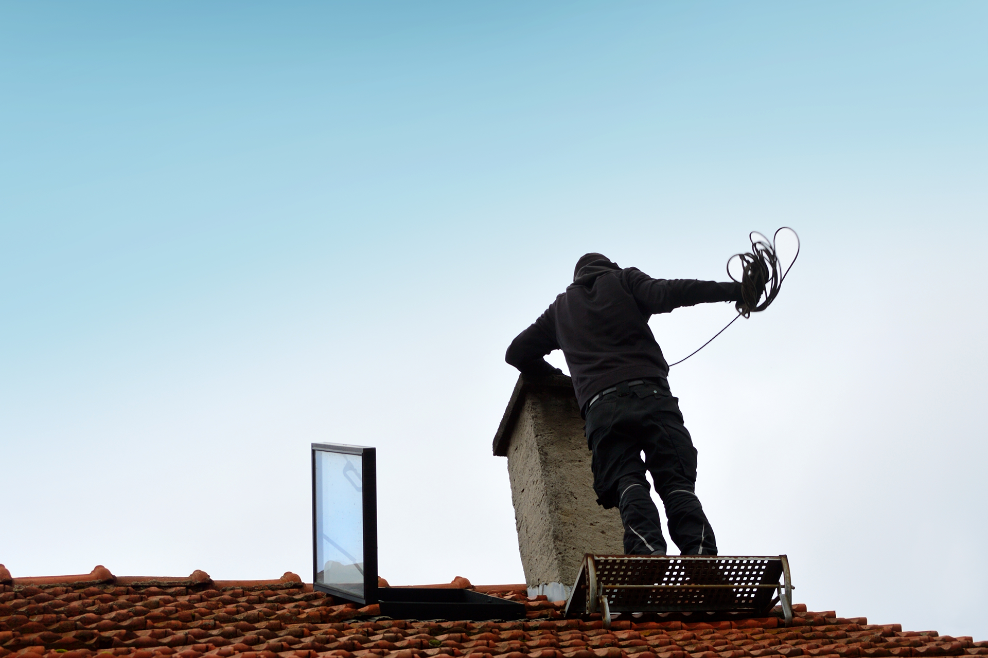 Chimney pro on roof cleaning chimney