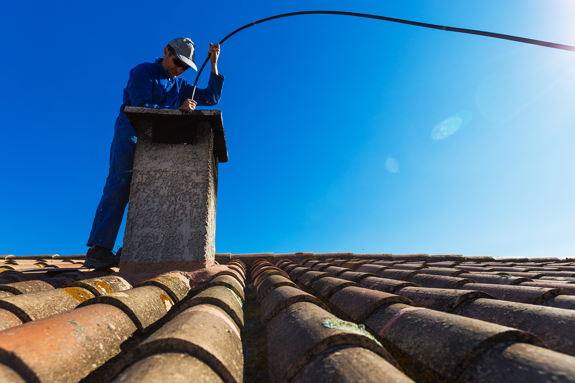 Chimney Sweep professional on roof cleaning chimney